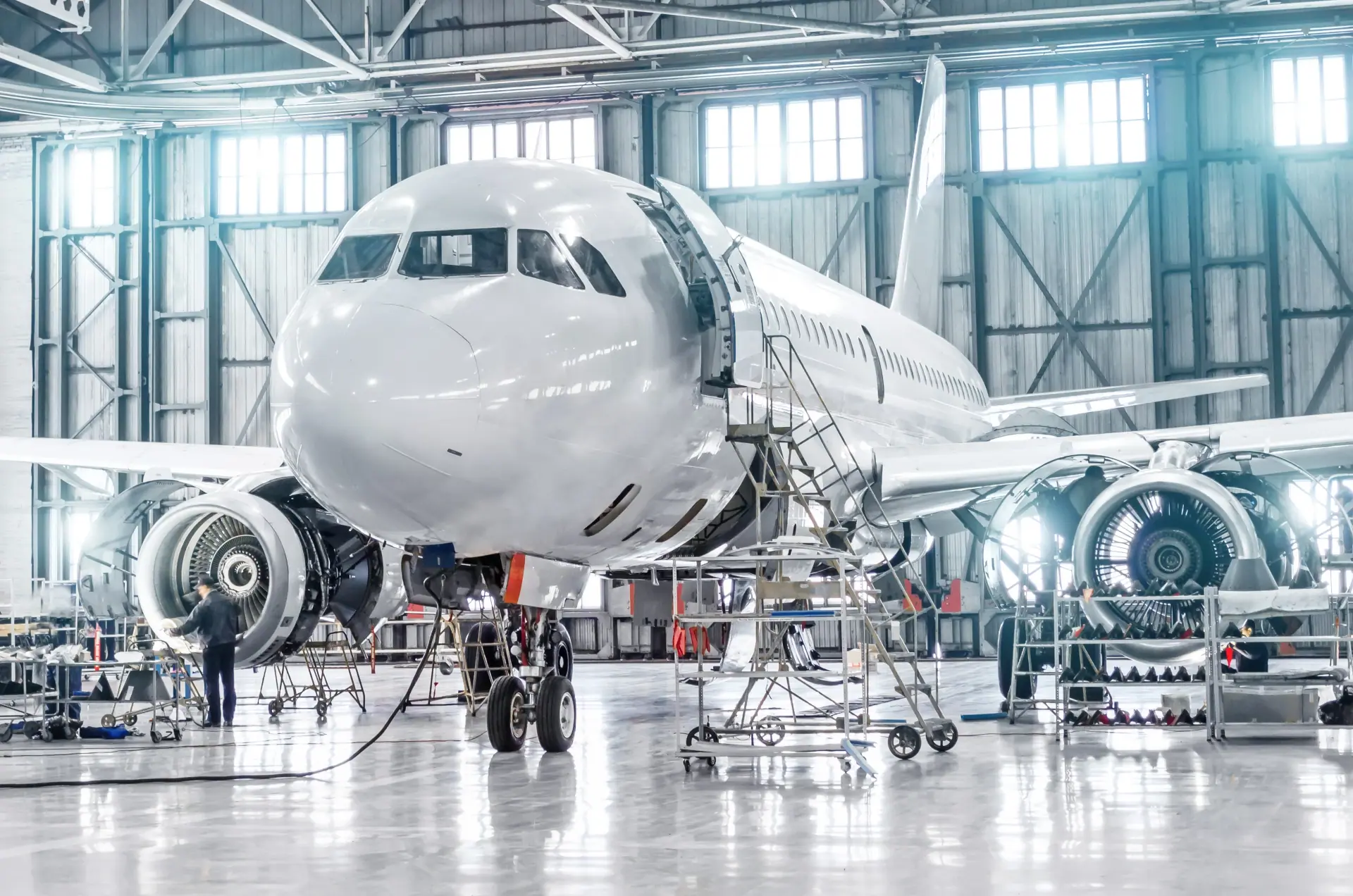 Commercial aircraft under maintenance in an aerospace hangar.